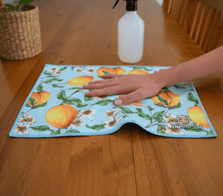 Hand wiping kitchen surface with DirtyGirl Lemon Twist Cloth – Lint-free finish
