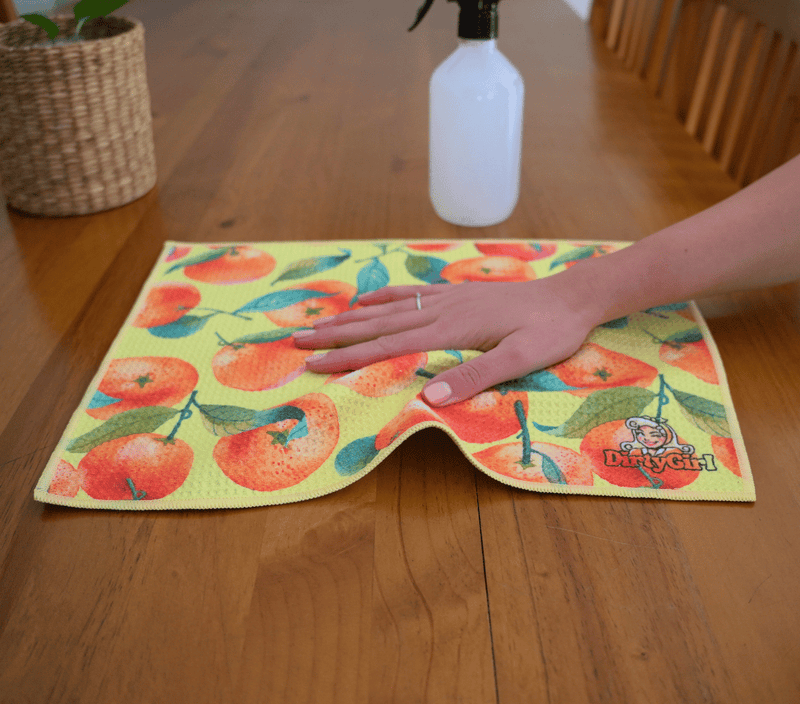 Hand wiping kitchen surface with DirtyGirl Orange Zest Cloth – Lint-free finish