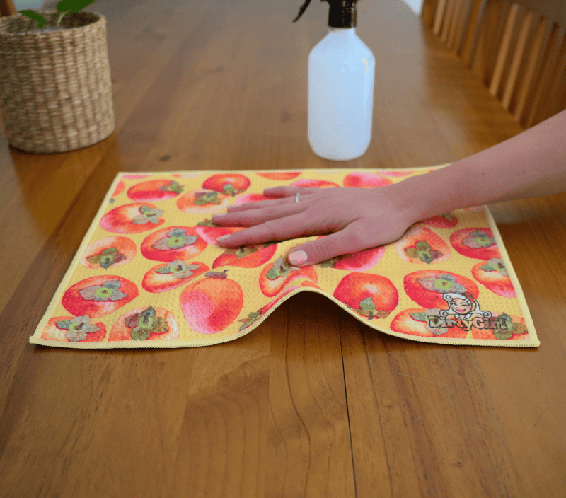 Hand wiping kitchen surface with DirtyGirl Persimmon Polish Cloth – Lint-free finish