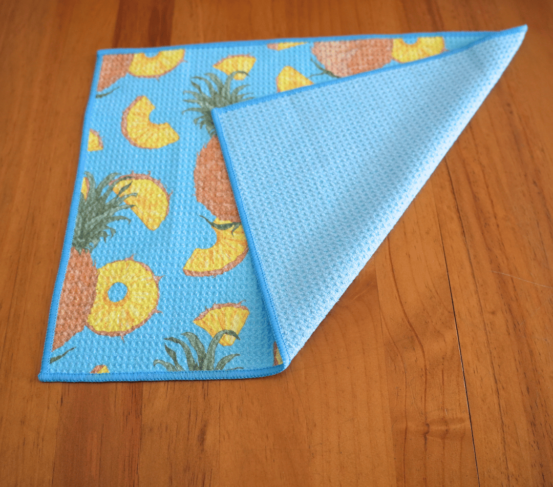Folded DirtyGirl Pineapple Express Cloth displayed on bench – Reusable and eco-friendly