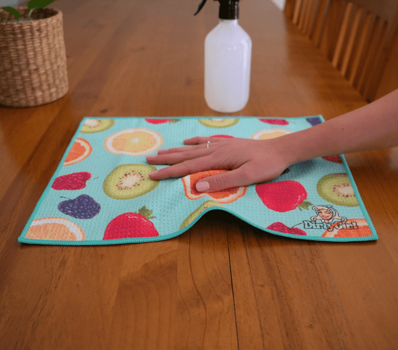 Hand wiping kitchen surface with DirtyGirl Tutti Frutti Cloth – Lint-free finish